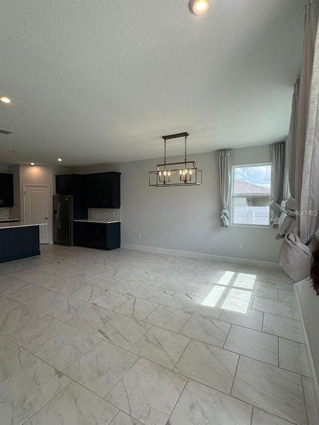 interior space featuring a chandelier and a textured ceiling