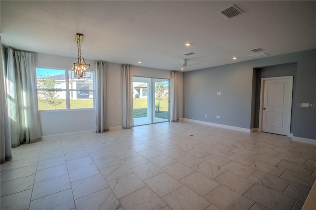 empty room featuring baseboards, a textured ceiling, visible vents, and a wealth of natural light