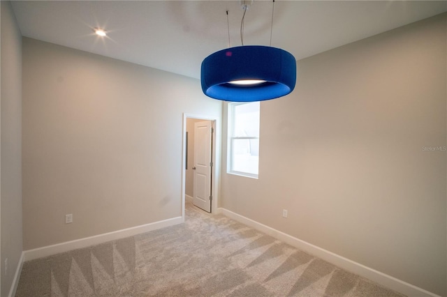 carpeted spare room featuring baseboards