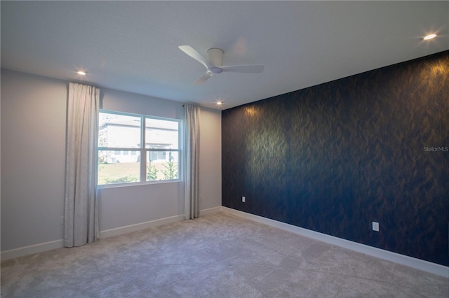 spare room with baseboards, carpet floors, recessed lighting, and an accent wall