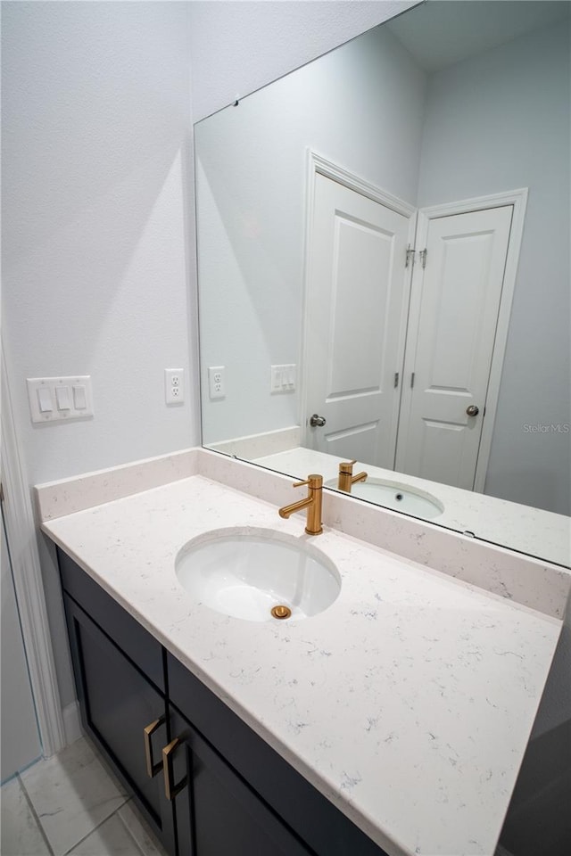 bathroom with marble finish floor and vanity