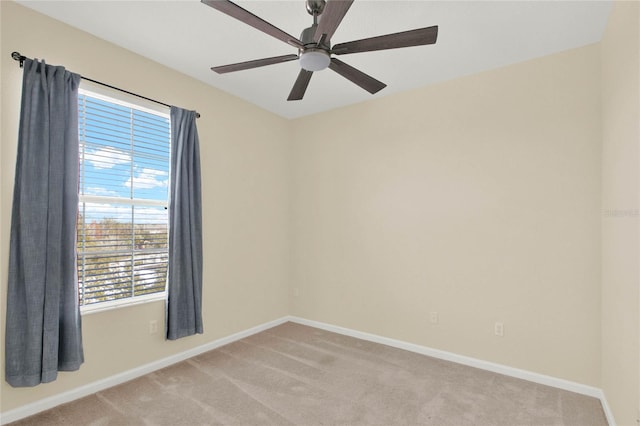 spare room featuring light carpet and ceiling fan