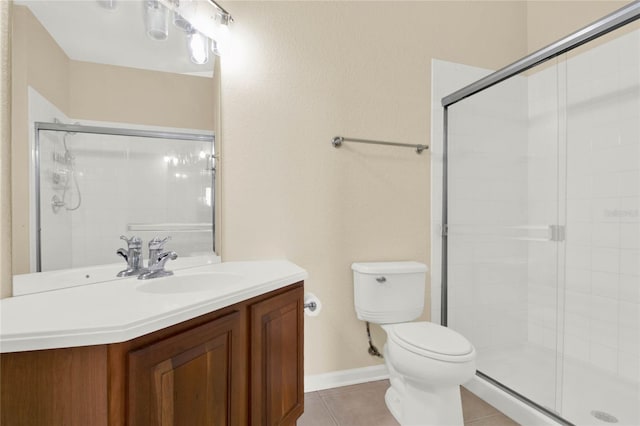 bathroom with vanity, a shower with door, tile patterned floors, and toilet