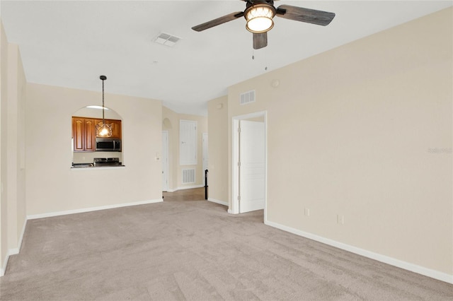 unfurnished living room featuring light colored carpet and ceiling fan