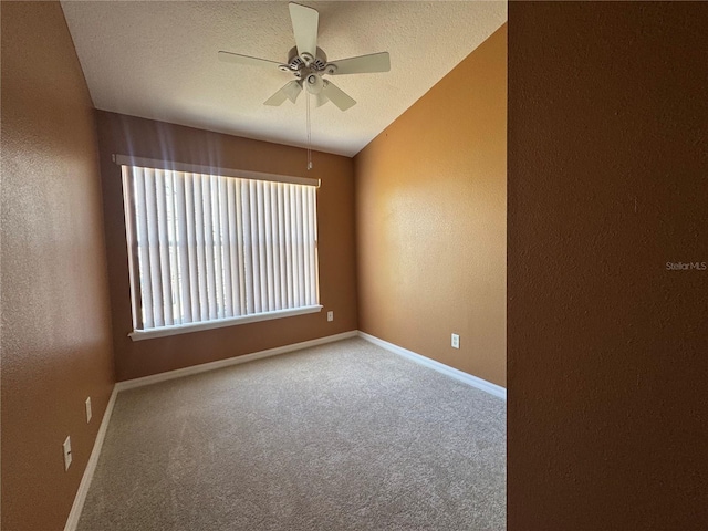 unfurnished room featuring ceiling fan, vaulted ceiling, a textured ceiling, and carpet flooring