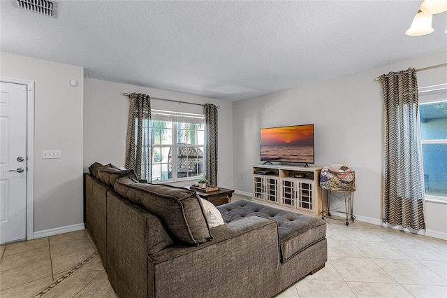 living room with a textured ceiling and light tile patterned flooring