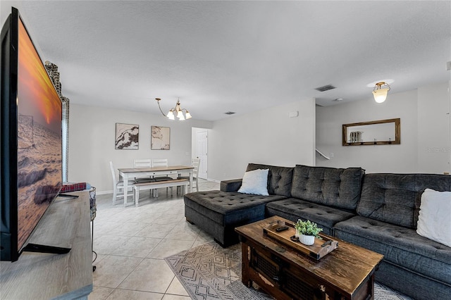 living room with a notable chandelier, a textured ceiling, and light tile patterned flooring