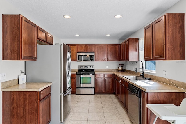 kitchen with sink, light tile patterned floors, a textured ceiling, and appliances with stainless steel finishes