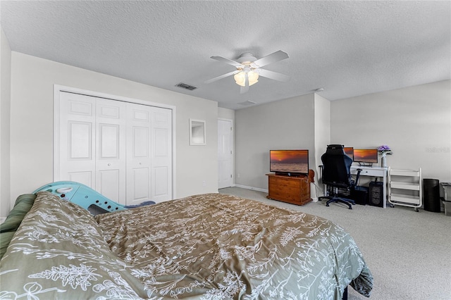 bedroom featuring a textured ceiling, a closet, ceiling fan, and carpet