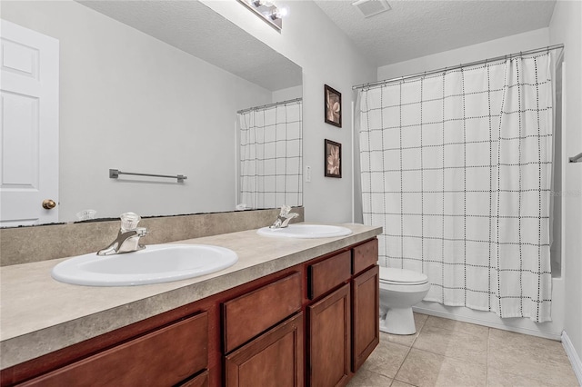 full bathroom featuring shower / tub combo with curtain, vanity, a textured ceiling, tile patterned floors, and toilet