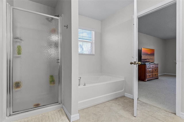 bathroom featuring tile patterned flooring and shower with separate bathtub