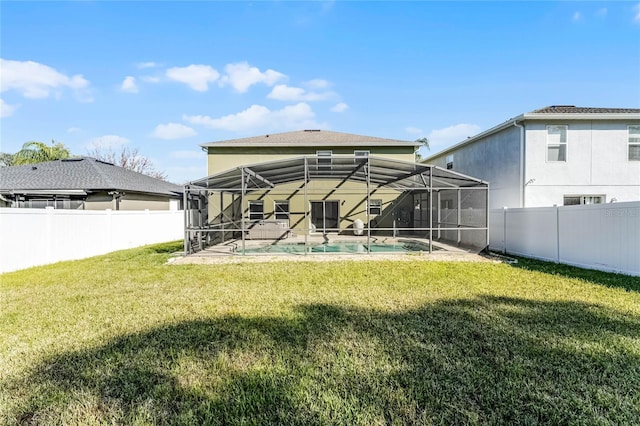 back of house featuring a fenced in pool, a yard, glass enclosure, and a patio area