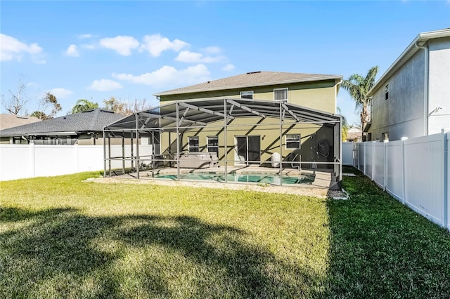 rear view of property with a yard, a lanai, a fenced in pool, and a patio area