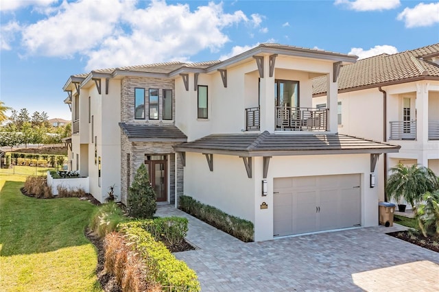 985 Jack Nicklaus Ct, Kissimmee, FL 34747 - view of front facade featuring a garage, a balcony, and a front lawn