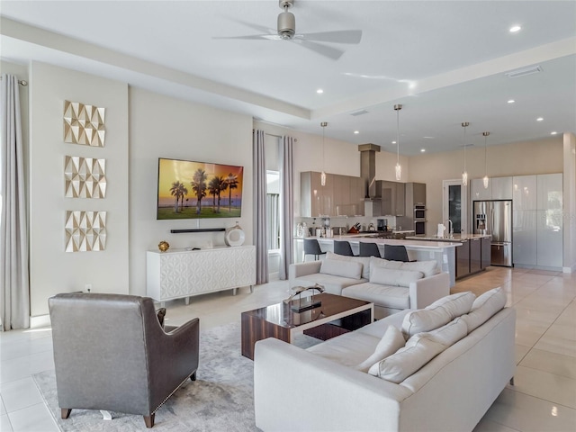 tiled living room with ceiling fan and sink