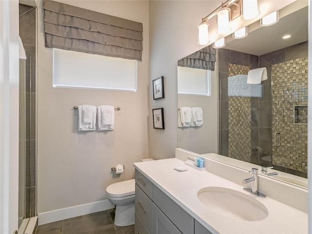 bathroom with a shower with door, vanity, tile patterned floors, and toilet