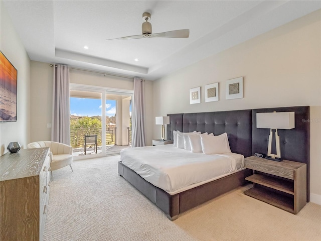 carpeted bedroom with access to exterior, a raised ceiling, and ceiling fan