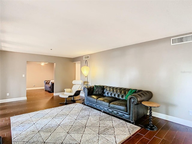 living room with dark wood-type flooring and ceiling fan