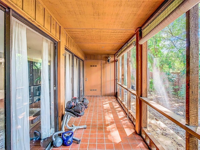 unfurnished sunroom featuring wood ceiling and a wealth of natural light