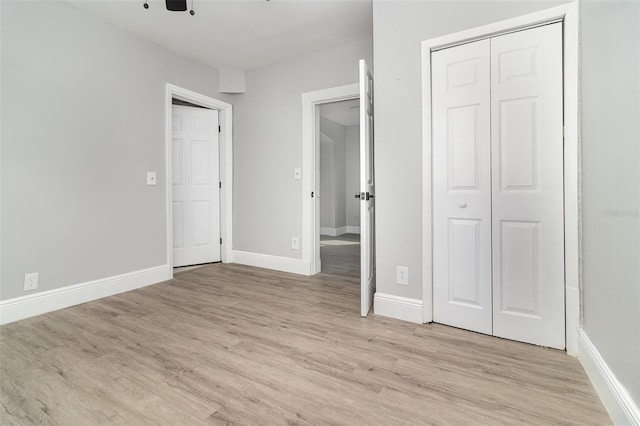 unfurnished bedroom featuring a closet and light wood-type flooring