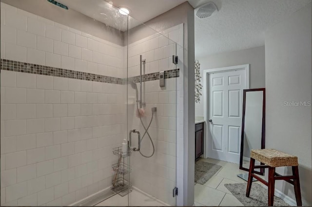 bathroom with vanity, a textured ceiling, an enclosed shower, and tile patterned floors