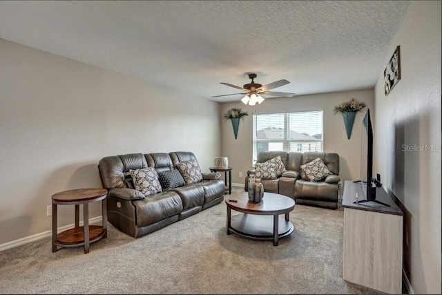 living room with ceiling fan, carpet floors, and a textured ceiling