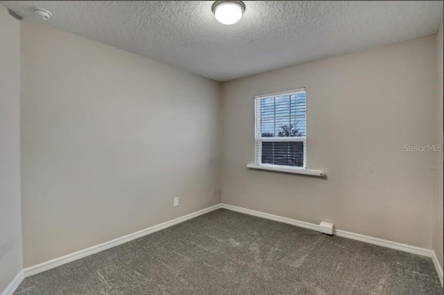 carpeted spare room with a textured ceiling