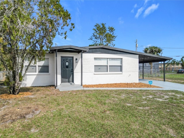 view of front of house featuring a carport and a front yard