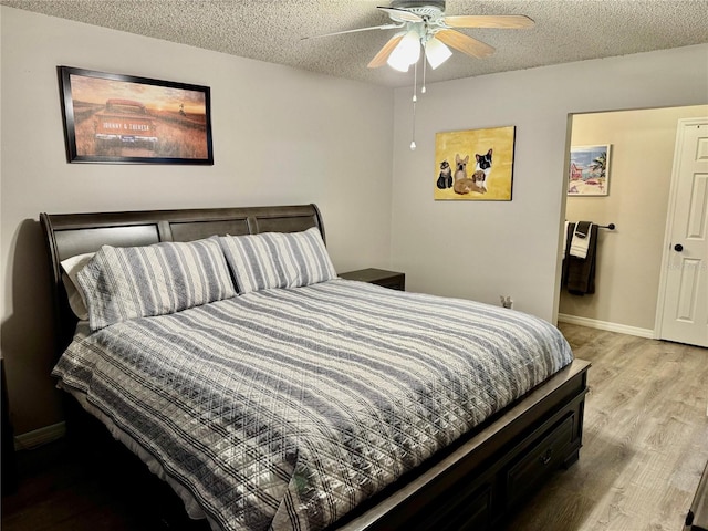 bedroom with ceiling fan, light hardwood / wood-style flooring, and a textured ceiling