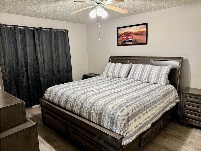 bedroom featuring ceiling fan, wood-type flooring, and a textured ceiling