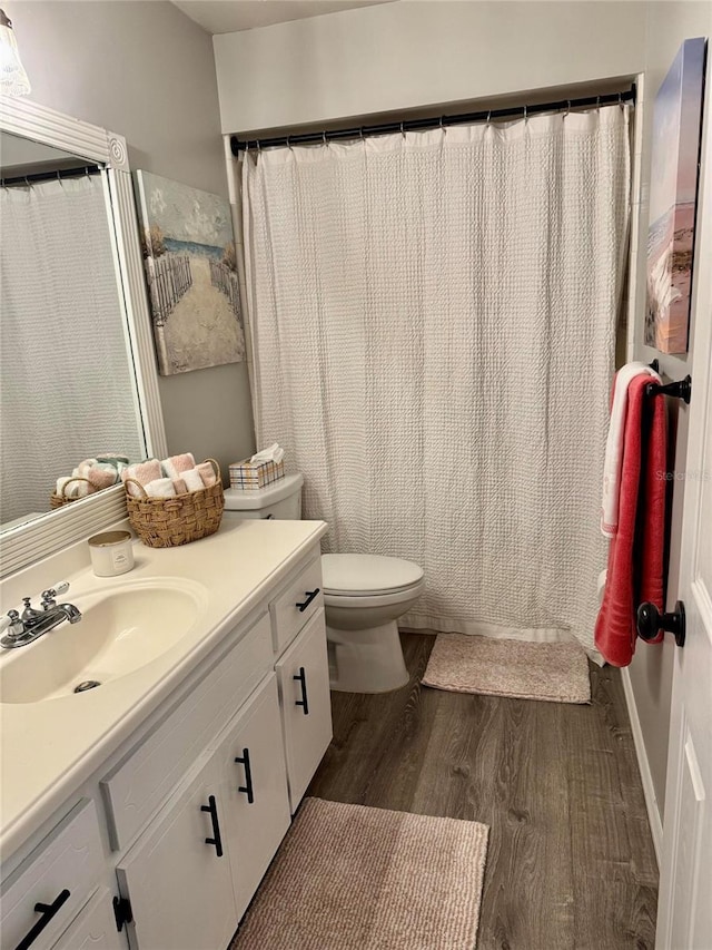 bathroom with vanity, toilet, and hardwood / wood-style floors