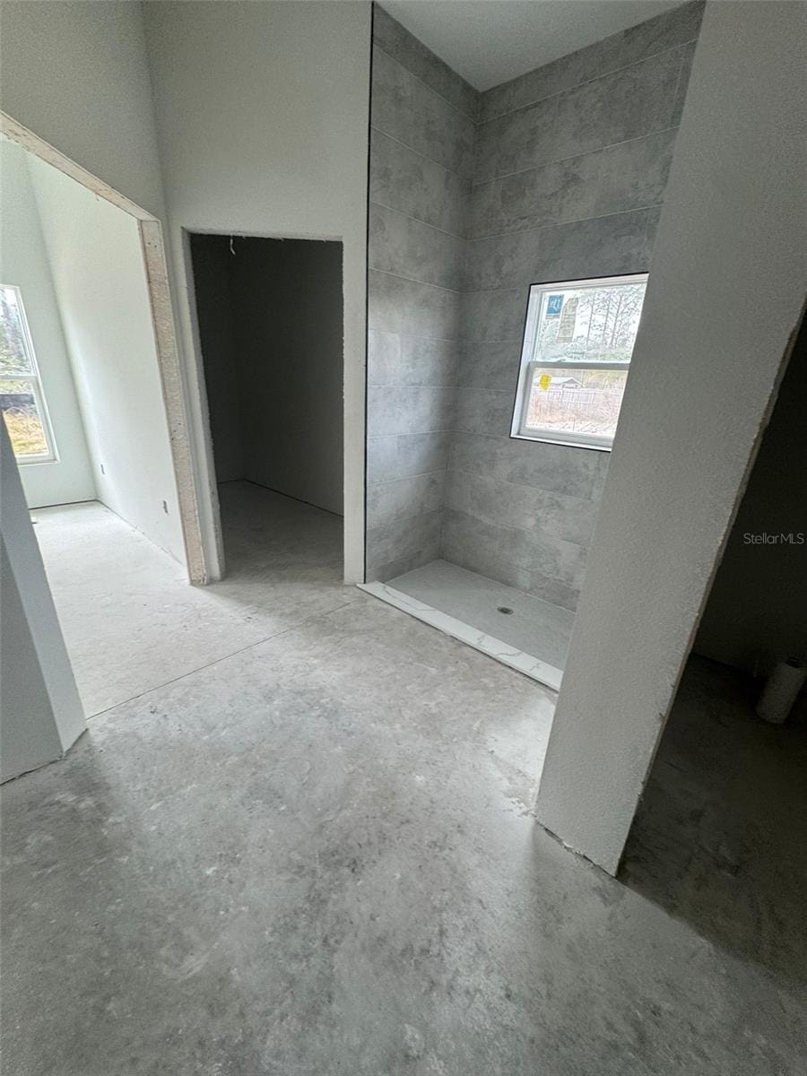 bathroom featuring concrete floors and a shower