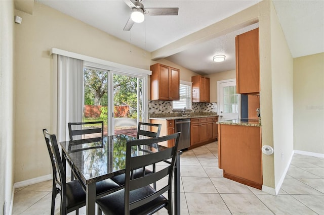 interior space featuring light stone countertops, backsplash, stainless steel dishwasher, and light tile patterned floors