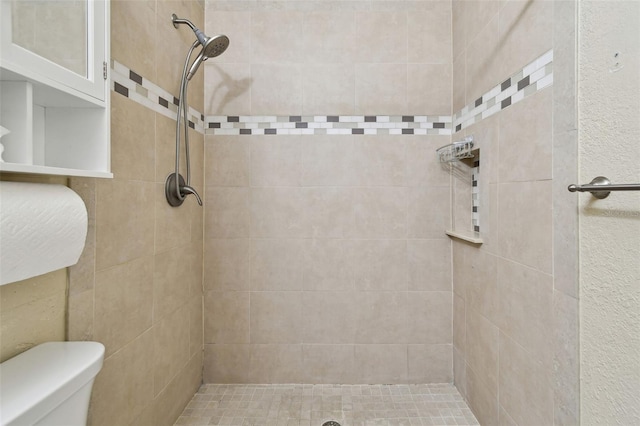 bathroom featuring tiled shower and toilet