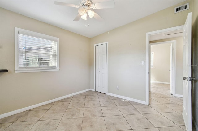 unfurnished bedroom with light tile patterned floors, a closet, and ceiling fan