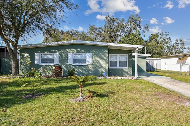 view of front of home featuring concrete driveway, a front lawn, and fence