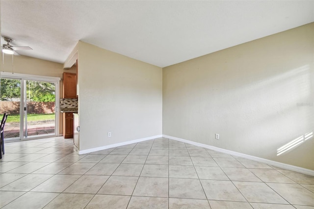 spare room with light tile patterned floors, baseboards, a ceiling fan, and vaulted ceiling