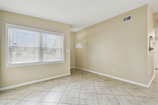 unfurnished room featuring light tile patterned floors, baseboards, and visible vents