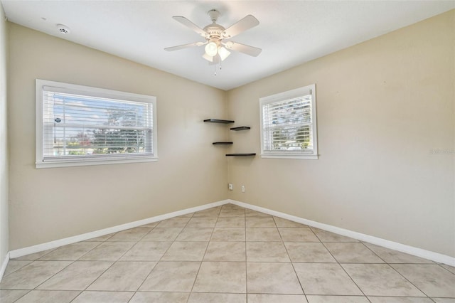 spare room with light tile patterned floors, baseboards, and a ceiling fan