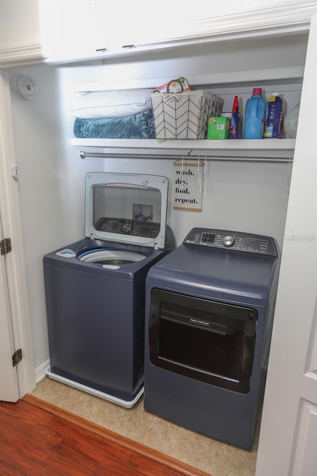 laundry room with hardwood / wood-style flooring and washer and clothes dryer