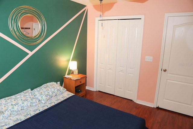 bedroom with dark hardwood / wood-style flooring and a closet