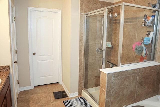 bathroom with walk in shower, vanity, and tile patterned flooring