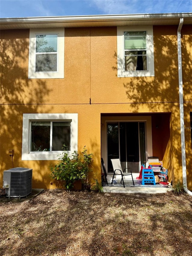 rear view of house featuring central AC and a patio area