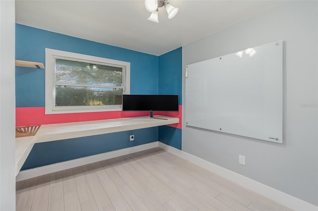 interior space featuring built in desk and light hardwood / wood-style flooring