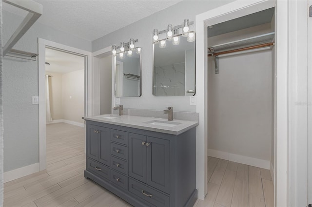 bathroom featuring vanity, hardwood / wood-style floors, and a textured ceiling