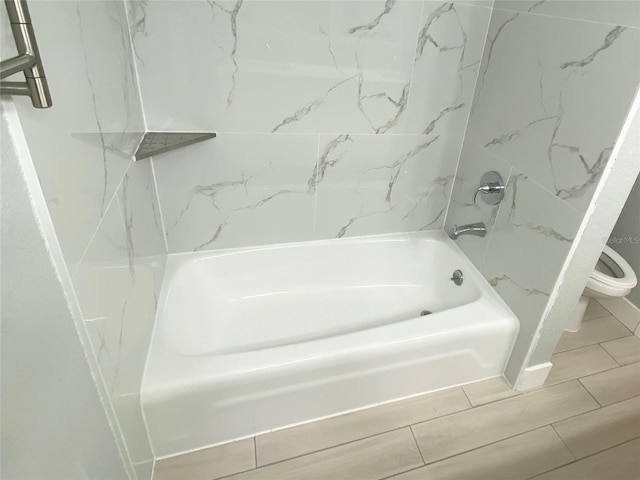 bathroom featuring shower / washtub combination and toilet