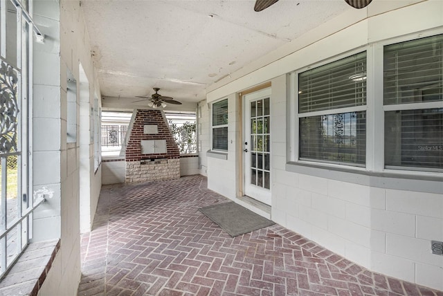 unfurnished sunroom with ceiling fan