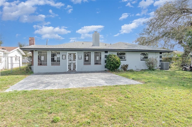 rear view of property featuring a yard, a patio area, and central air condition unit