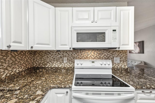 kitchen with tasteful backsplash, white appliances, dark stone counters, and white cabinets