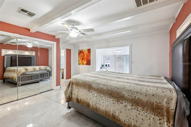 bedroom with beam ceiling, a closet, ceiling fan, and light tile patterned flooring